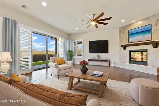 a view of a dining room and livingroom with furniture wooden floor a rug a potted plant and a chandelier