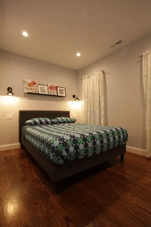 a bed sitting in a bedroom next to a lamp