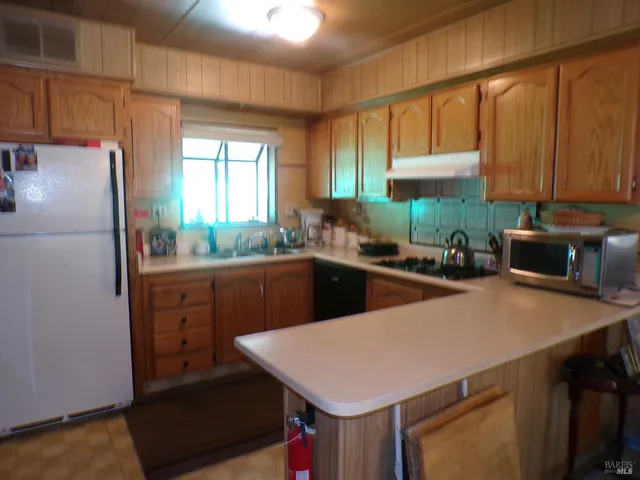 a kitchen with a sink a refrigerator and cabinets