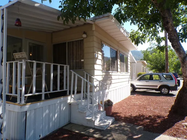 a view of a house with a small yard and wooden fence