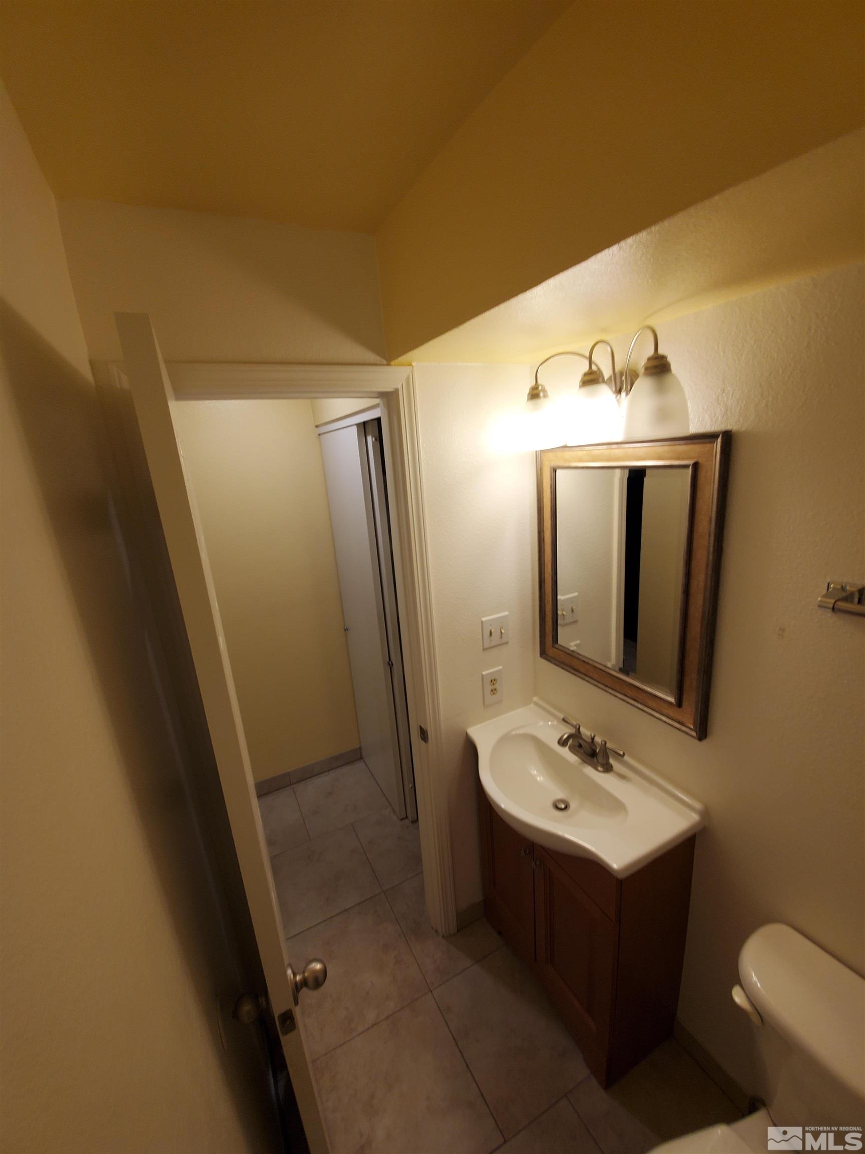 1422 East 9th Street, Unit 1 Reno, NV 89512 - Photo 11 of 22 a bathroom with a sink mirror and toilet