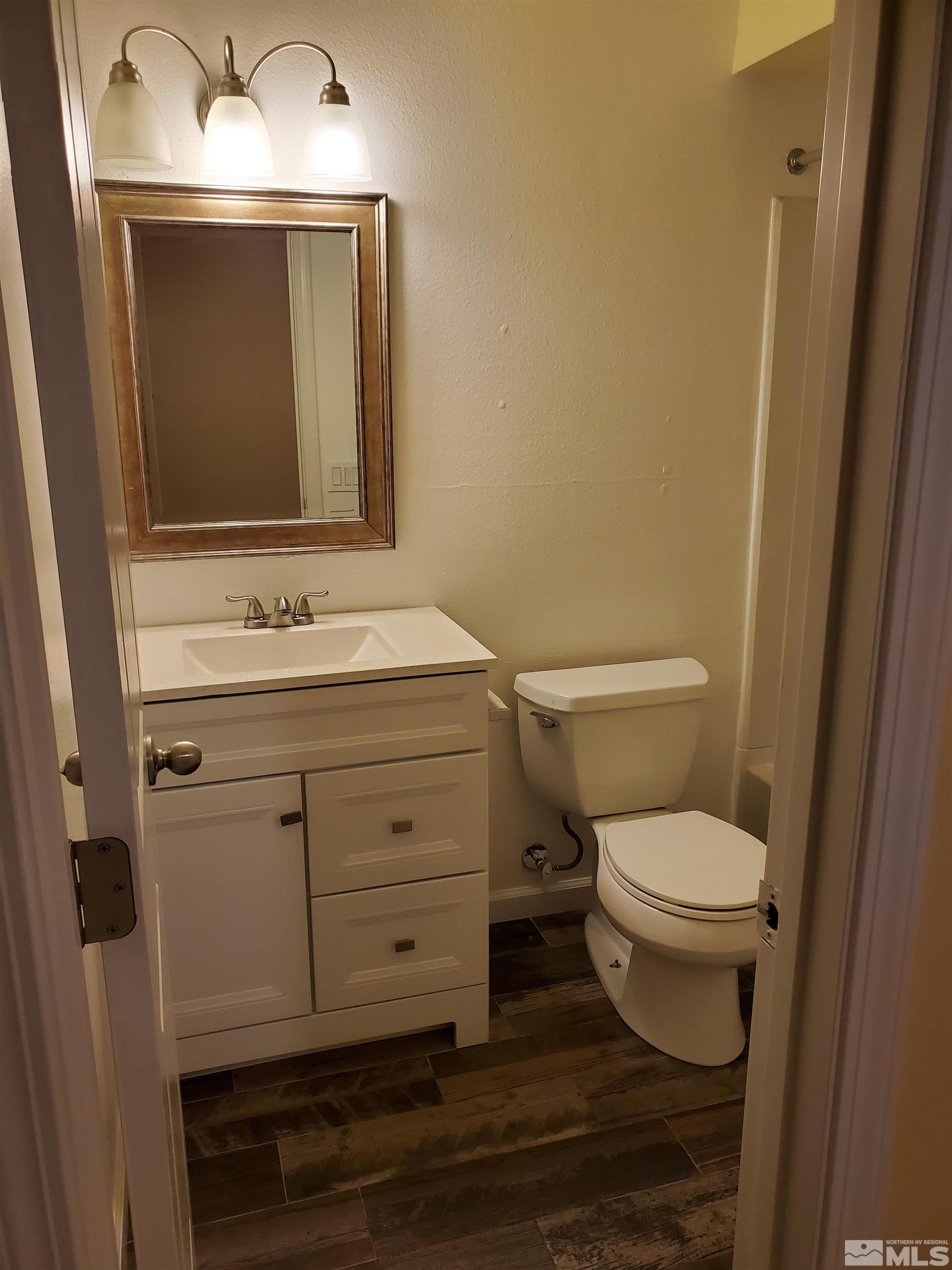 1422 East 9th Street, Unit 1 Reno, NV 89512 - Photo 20 of 22 a bathroom with a toilet sink and mirror