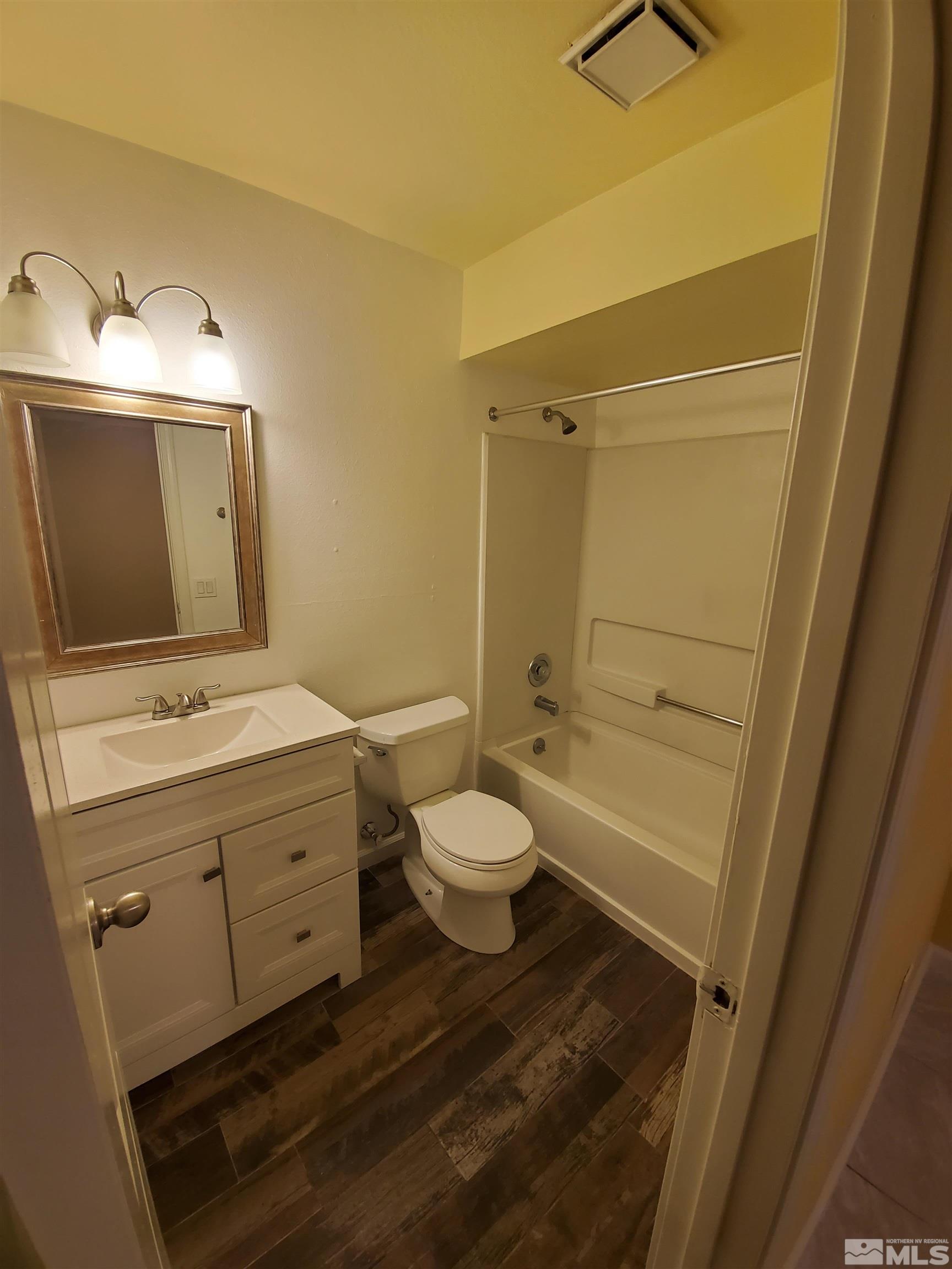 1422 East 9th Street, Unit 1 Reno, NV 89512 - Photo 21 of 22 a bathroom with a granite countertop sink toilet a mirror and bathtub
