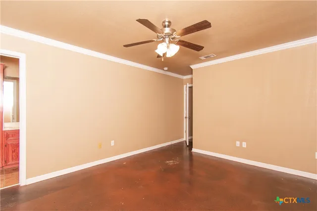 an empty room with a window and a fan