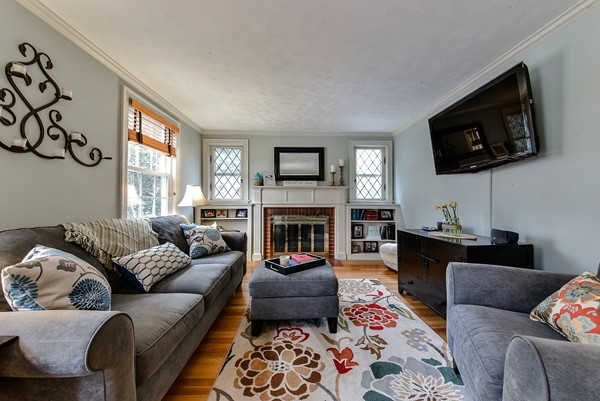 15 Charles Street Natick, MA 01760 - Photo 2 of 21 a living room with furniture a flat screen tv and a fireplace