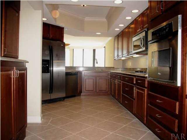 13335 Johnson Beach Road, Unit 802 Pensacola, FL 32507 - Photo 3 of 24 Large foyer entry leads to main living area. Kitchen is to right. Notice tiled flooring and crown molding throughout unit.