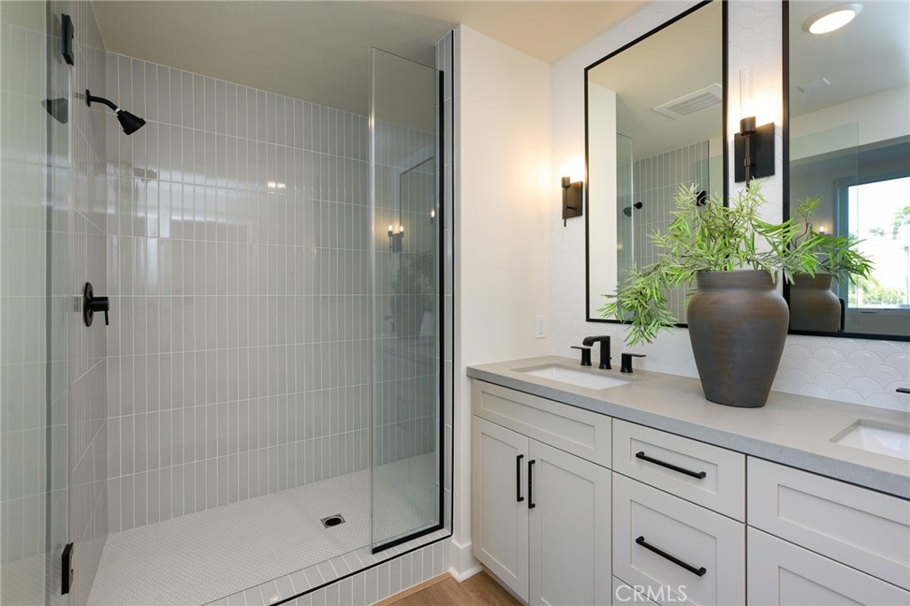 414 Main Street, Unit 400 Huntington Beach, CA 92648 - Photo 14 of 29 a bathroom with a shower sink and mirror