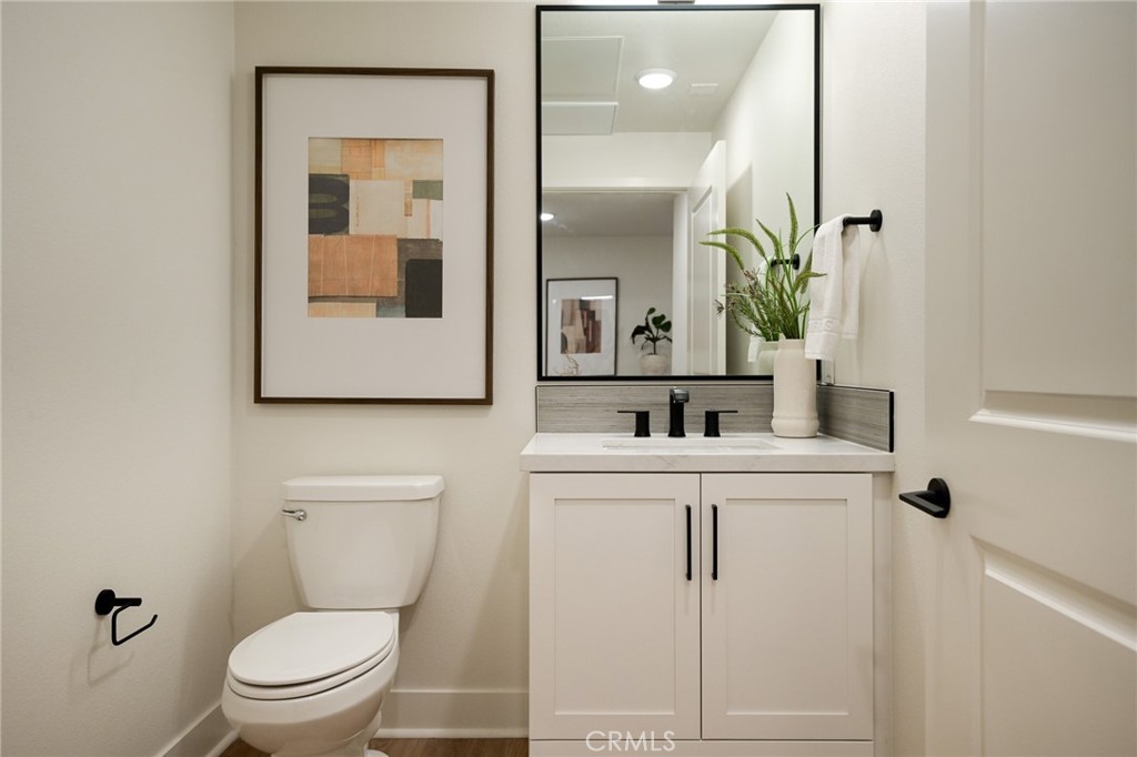 414 Main Street, Unit 400 Huntington Beach, CA 92648 - Photo 6 of 29 a bathroom with a toilet a sink and mirror