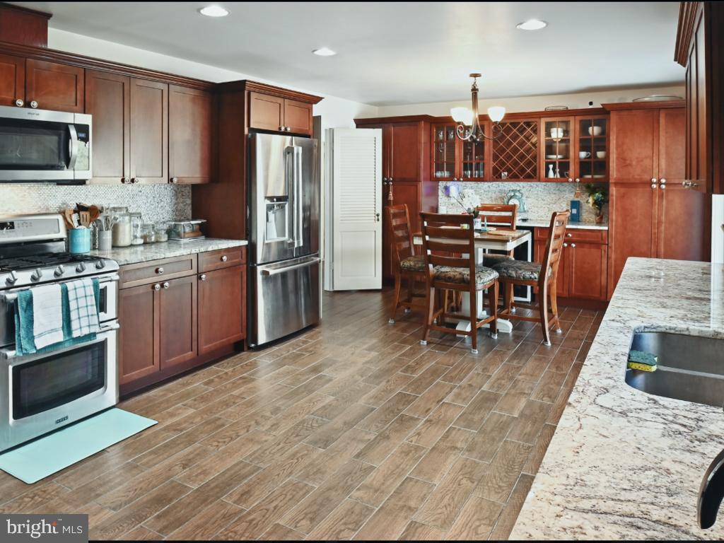 60 Windsor Lane Willingboro, NJ 08046 - Photo 24 of 58 a kitchen with stainless steel appliances kitchen island granite countertop a refrigerator a stove a sink a dining table and chairs