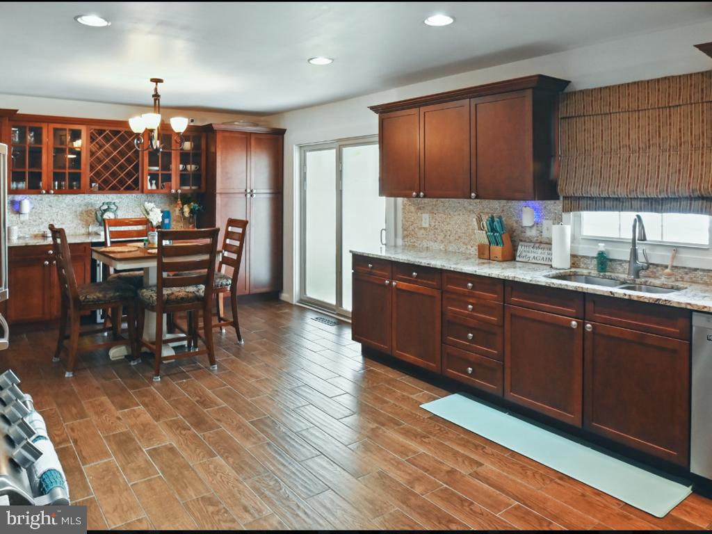 60 Windsor Lane Willingboro, NJ 08046 - Photo 26 of 58 a kitchen with stainless steel appliances granite countertop wooden cabinets a dining table and chairs
