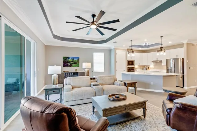 a kitchen with stainless steel appliances a stove a sink dishwasher a refrigerator and white cabinets with wooden floor