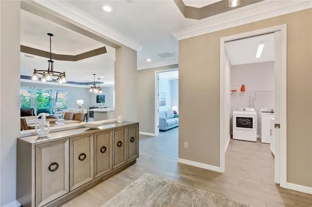 a dining room with furniture a chandelier and wooden floor