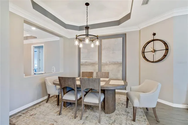 a dining room with wooden floor and a chandelier