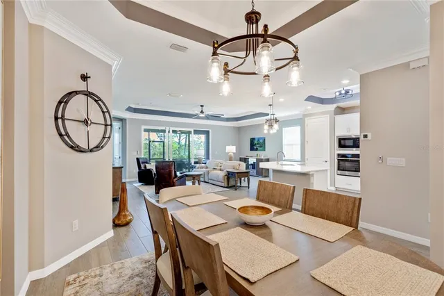 a living room with furniture floor to ceiling window hardwood floor and a flat screen tv