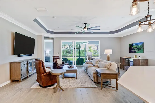 a living room with furniture a flat screen tv and a large window