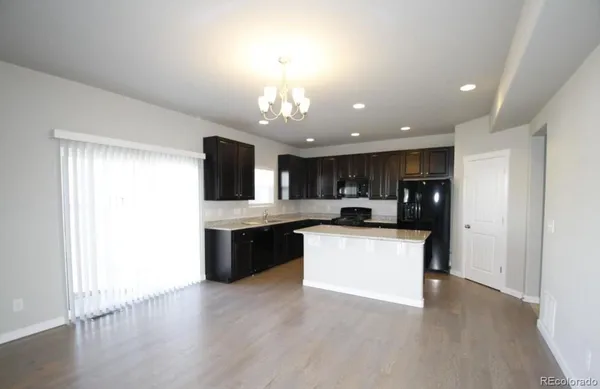 a large kitchen with a large counter top appliances and cabinets