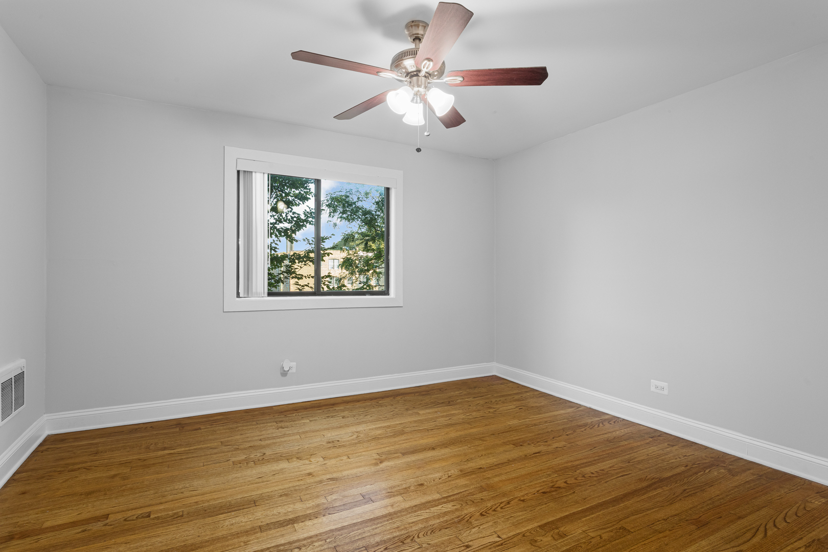 7545 North Winchester Avenue, Unit 303 Chicago, IL 60626 - Photo 11 of 13 wooden floor in an empty room with a window