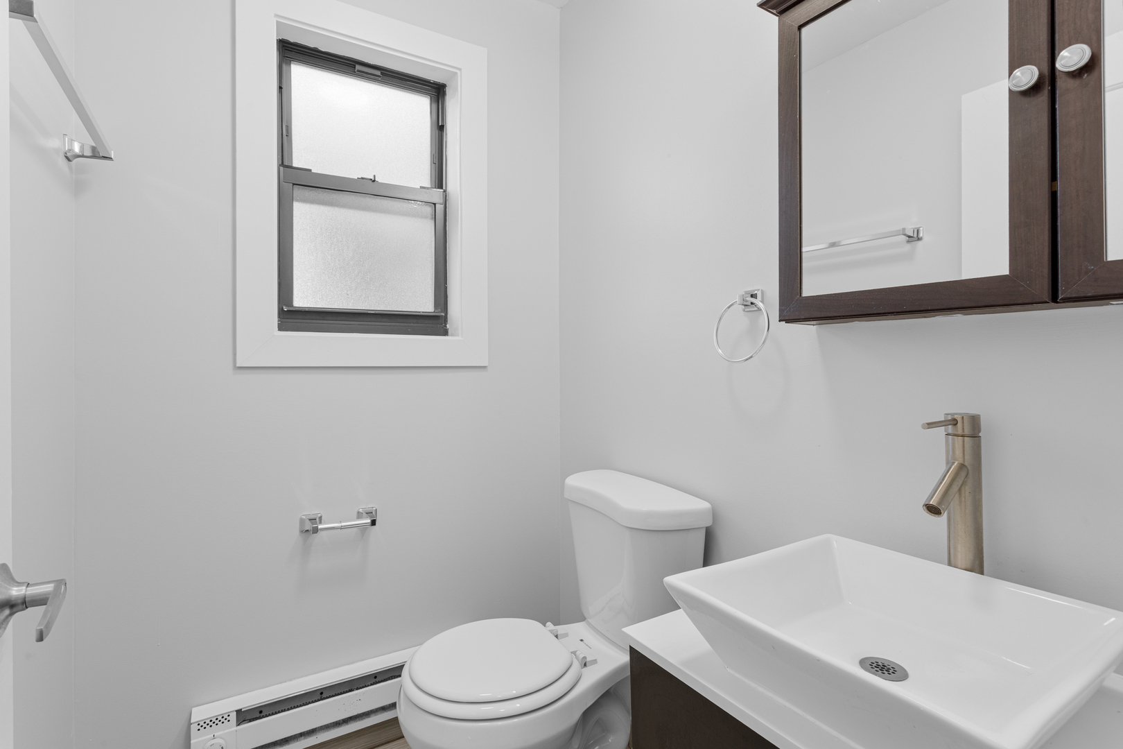 7545 North Winchester Avenue, Unit 303 Chicago, IL 60626 - Photo 12 of 13 a white toilet sitting next to a bathroom sink