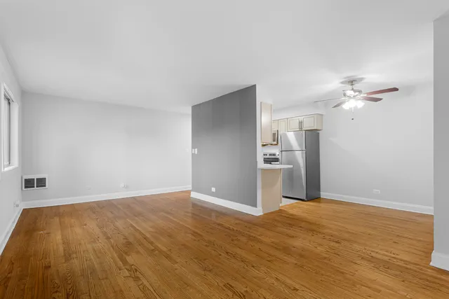 a view of empty room with wooden floor