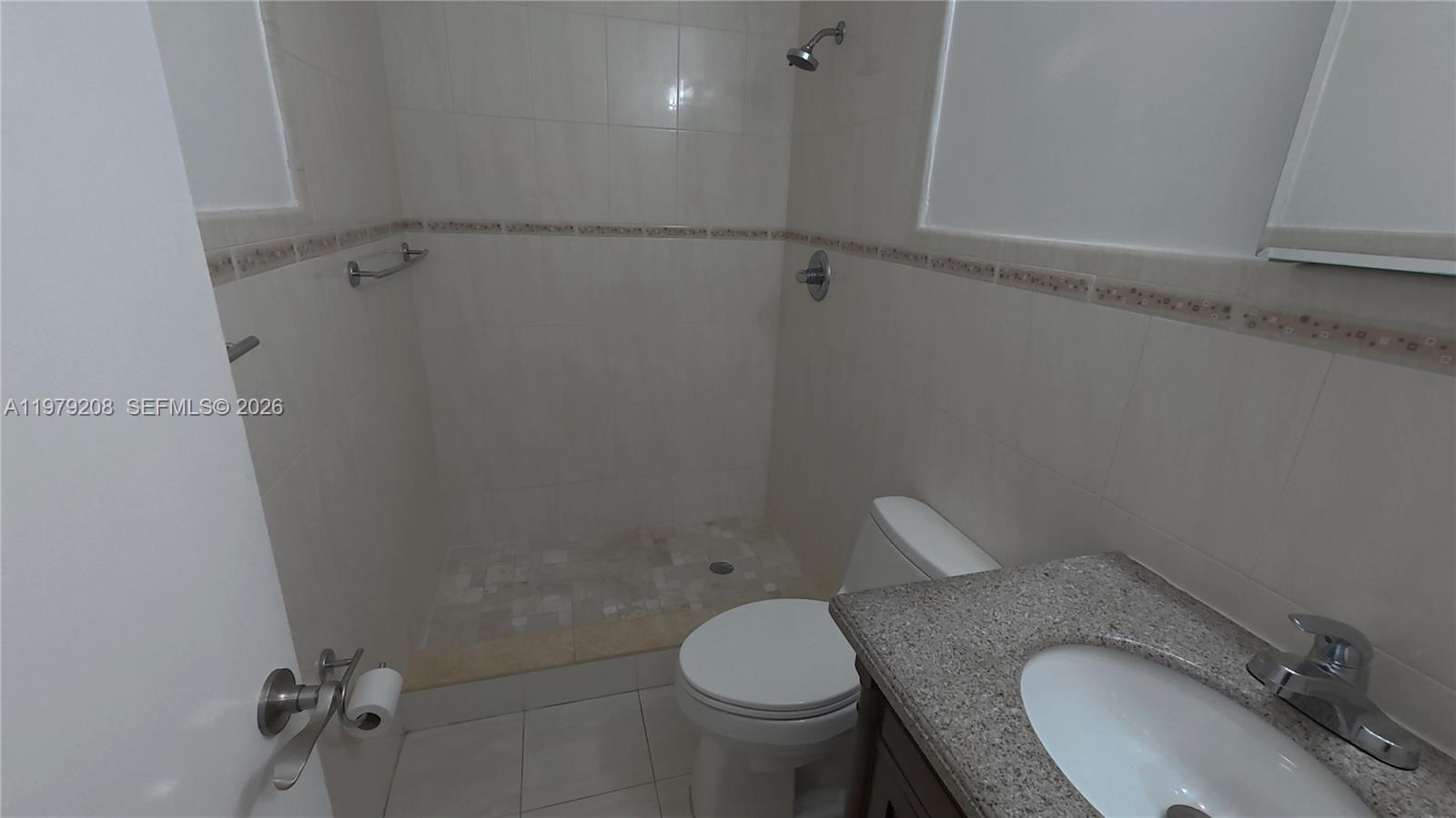 7121 Southwest 129th Avenue, Unit 8 Miami, FL 33183 - Photo 7 of 13 a bathroom with a granite countertop toilet and a sink