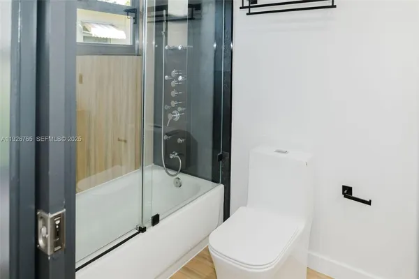 a white toilet sitting next to a bath tub