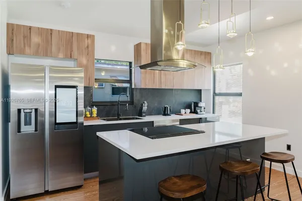 a kitchen with a sink a refrigerator and chairs