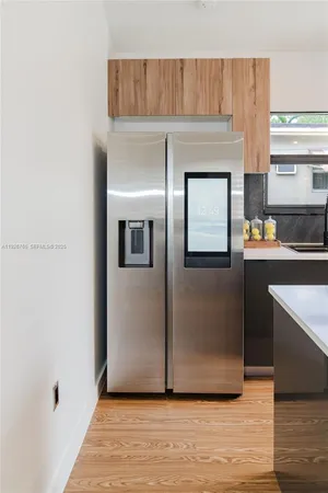 a view of a kitchen with wooden floor and electronic appliances