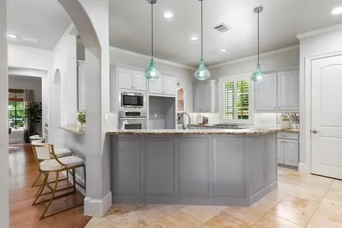 a kitchen with stainless steel appliances kitchen island granite countertop a stove a sink and a refrigerator