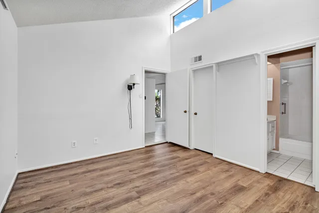 an empty room with wooden floor and closet