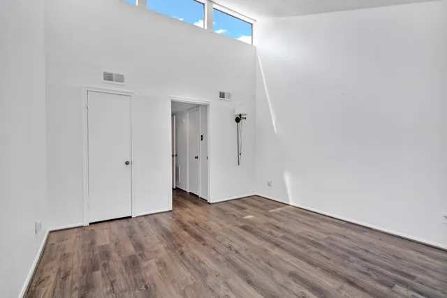 a view of a room with wooden floor and white walls
