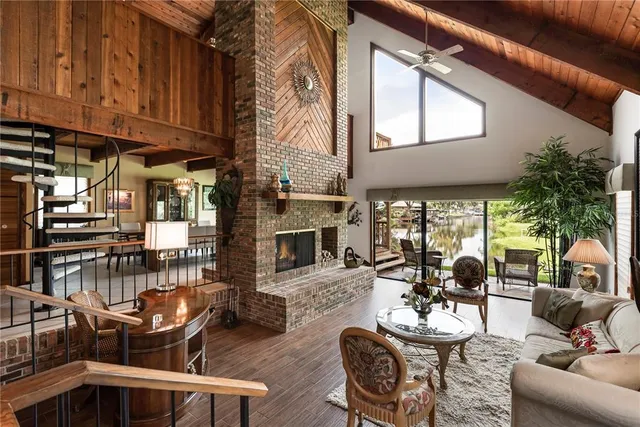 a living room with furniture a fireplace and lots of windows