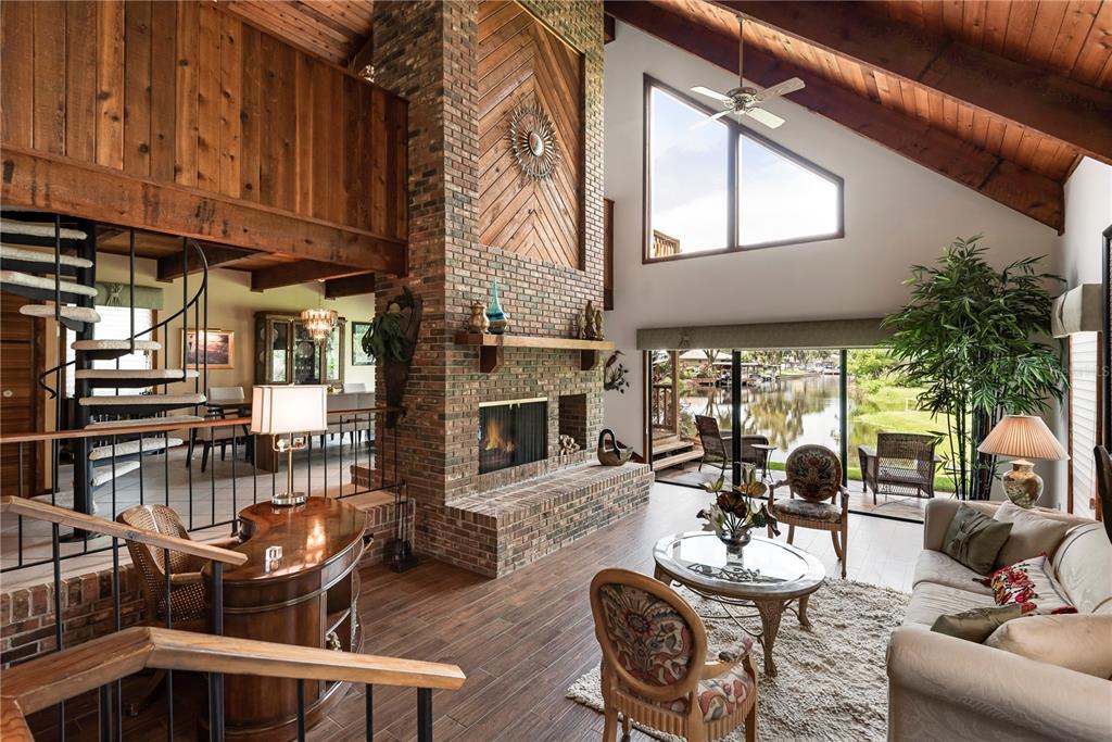 112 1st Street Tavares, FL 32778 - Photo 2 of 38 a living room with furniture a fireplace and lots of windows
