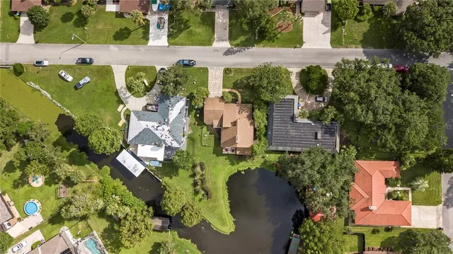 an aerial view of a residential houses with yard