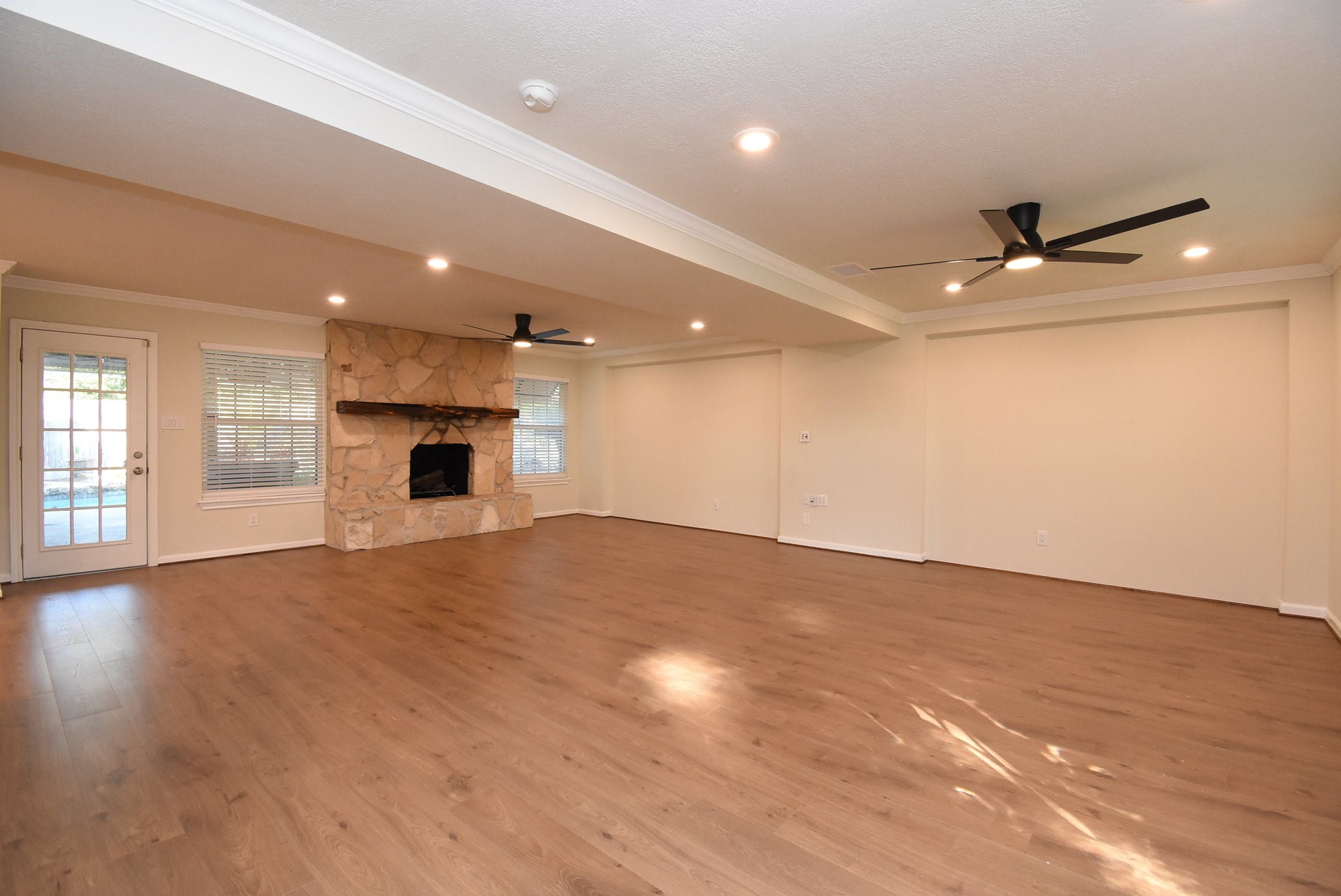 2503 Southwick Street Houston, TX 77080 - Photo 11 of 46 an empty room with wooden floor a ceiling fan and windows