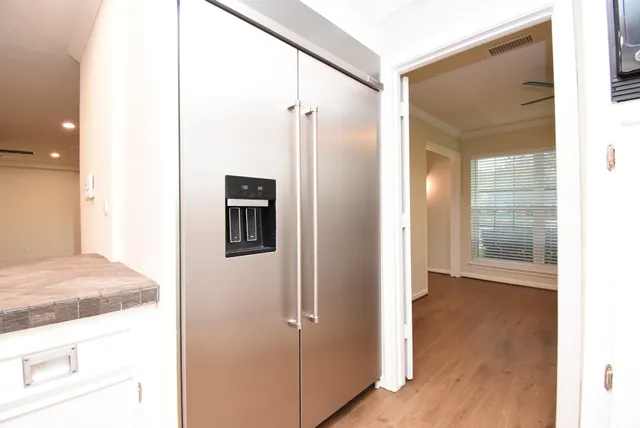 a large kitchen with stainless steel appliances granite countertop a hardwood floor and a sink
