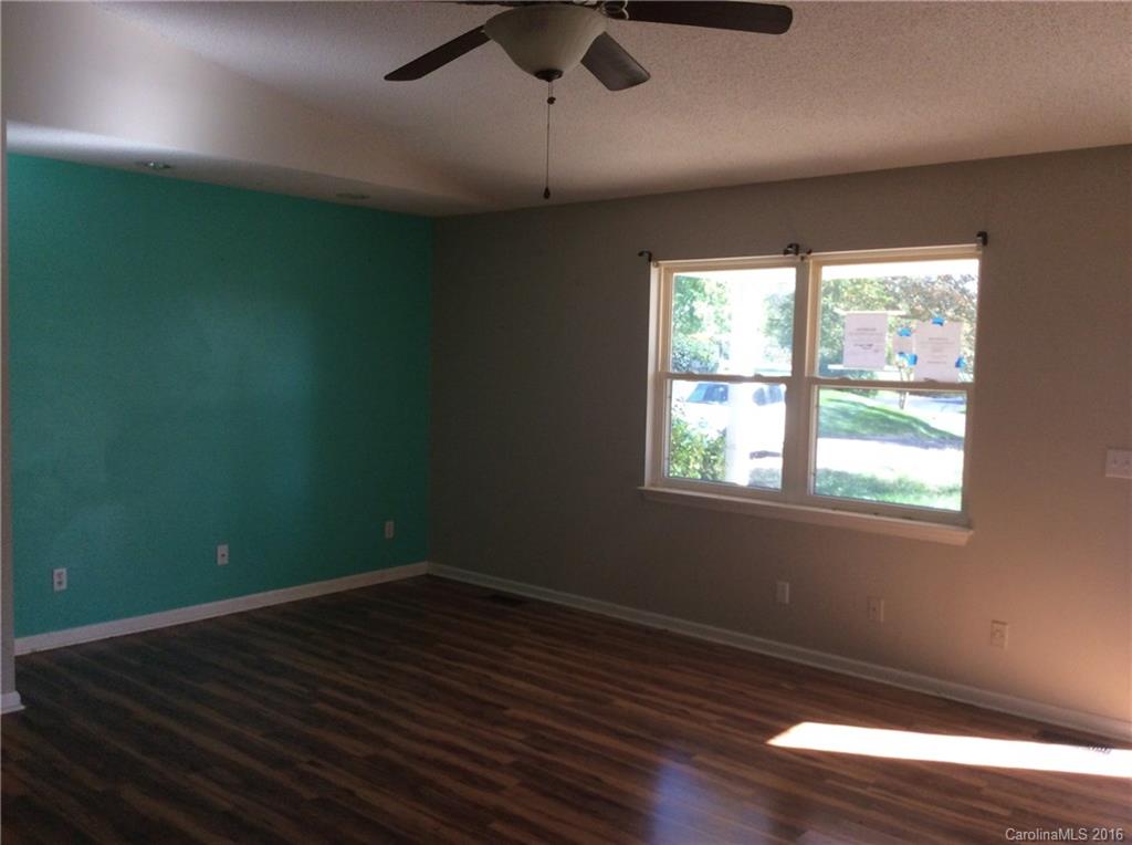 7827 Fisher Road Mount Pleasant, NC 28124 - Photo 2 of 5 an empty room with wooden floor and windows
