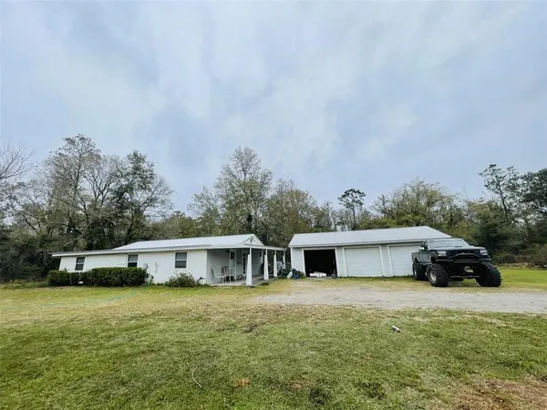a front view of a house with a garden and trees
