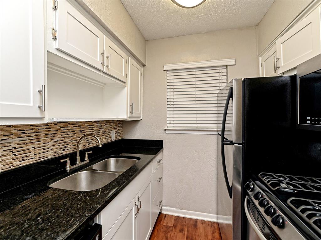 2401 Manor Road, Unit 120 Austin, TX 78722 - Photo 20 of 34 a kitchen with granite countertop a sink stove and refrigerator