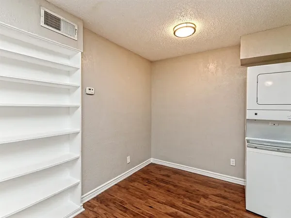 a view of a hallway with wooden floor and closet