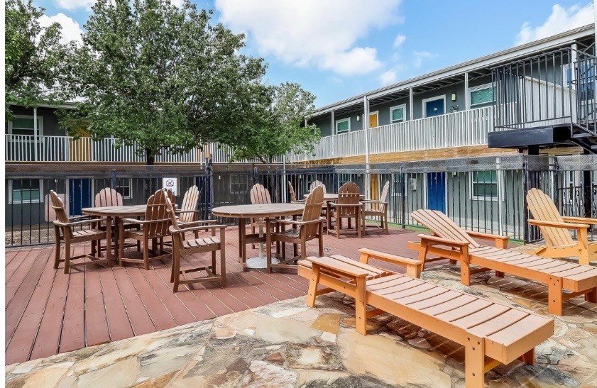 2401 Manor Road, Unit 120 Austin, TX 78722 - Photo 29 of 34 a view of a patio with a dining table and chairs with wooden floor and fence