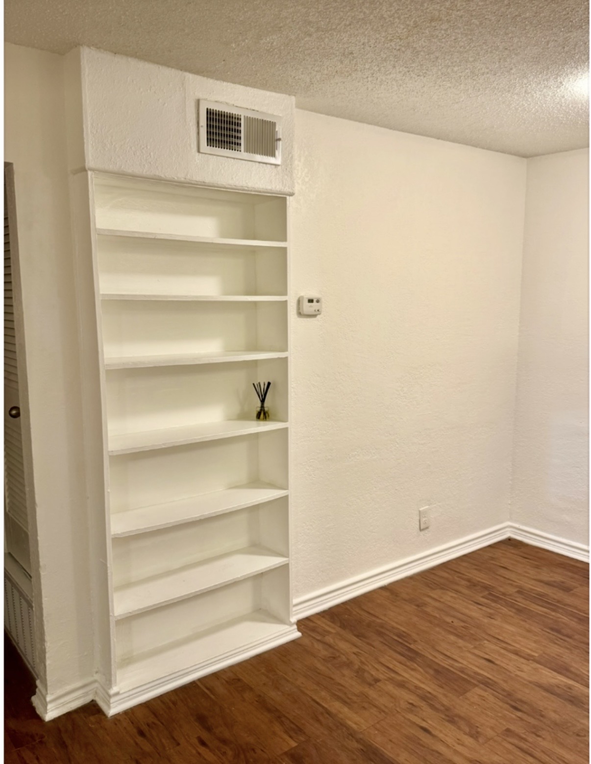 2401 Manor Road, Unit 120 Austin, TX 78722 - Photo 9 of 34 a view of an empty room with wooden floor and a window