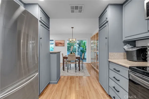a kitchen with stainless steel appliances granite countertop a refrigerator and a table
