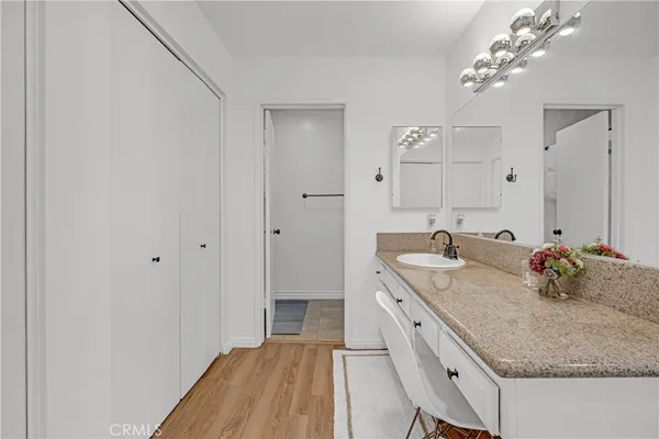 a bathroom with a granite countertop sink a mirror and vanity