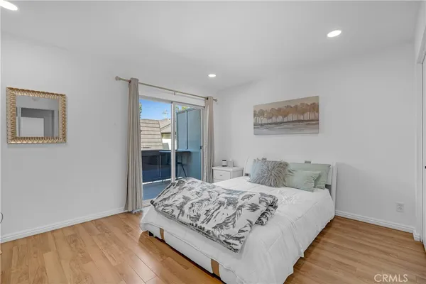 a bedroom with a bed a chair and a flat screen tv