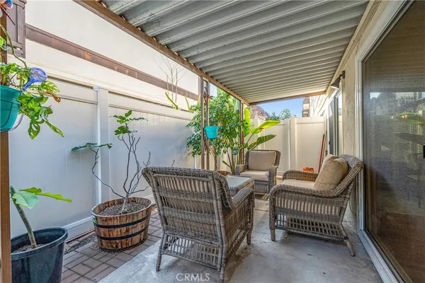 a view of a patio with dining table and chairs with wooden floor and fence