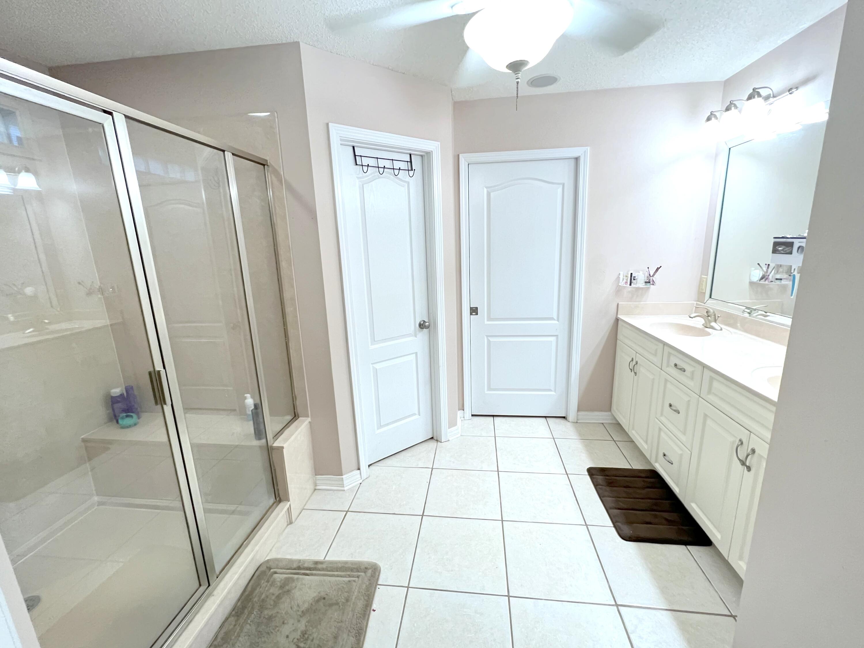 5633 North Brook Drive Crestview, FL 32539 - Photo 8 of 28 a bathroom with a glass door shower a sink and a mirror
