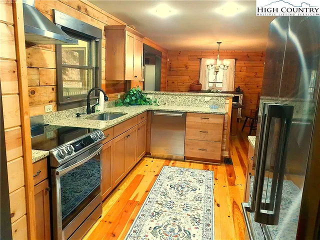 a kitchen with stainless steel appliances granite countertop a sink and a stove