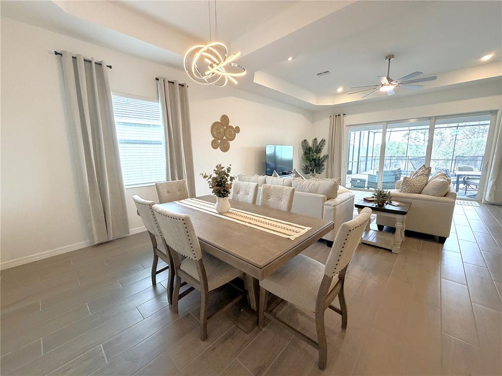 13081 Tulum Loop Venice, FL 34293 - Photo 11 of 48 a view of a dining room with furniture wooden floor and a chandelier