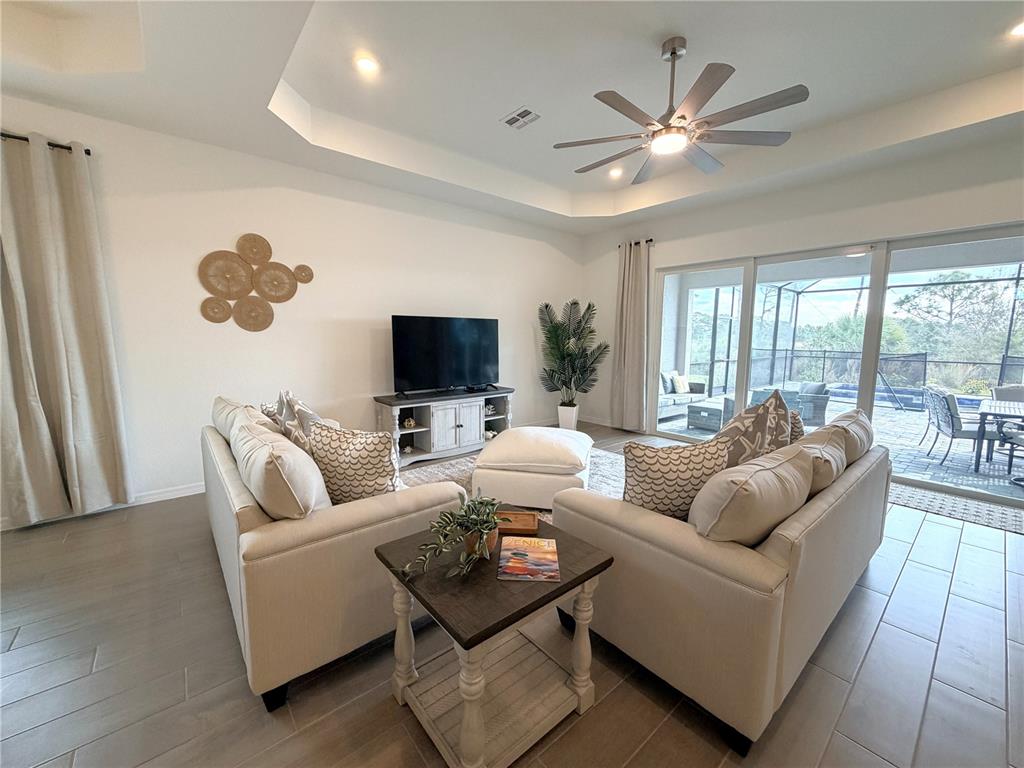 13081 Tulum Loop Venice, FL 34293 - Photo 16 of 48 a living room with furniture and a flat screen tv