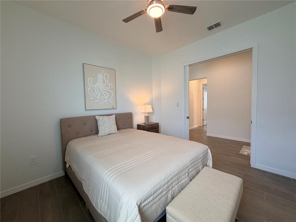 13081 Tulum Loop Venice, FL 34293 - Photo 23 of 48 a bedroom with a bed and a chandelier